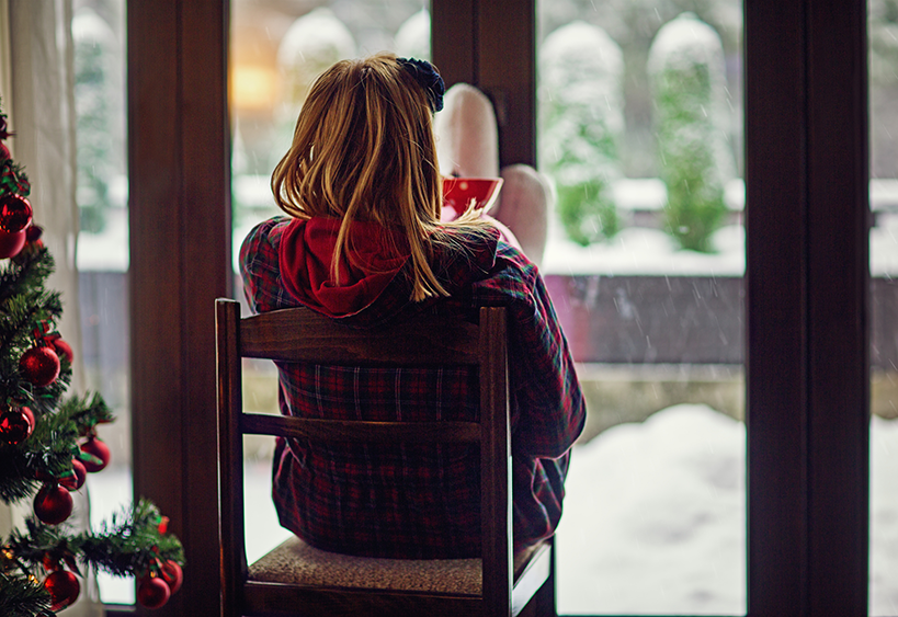 woman staring out window during holiday
